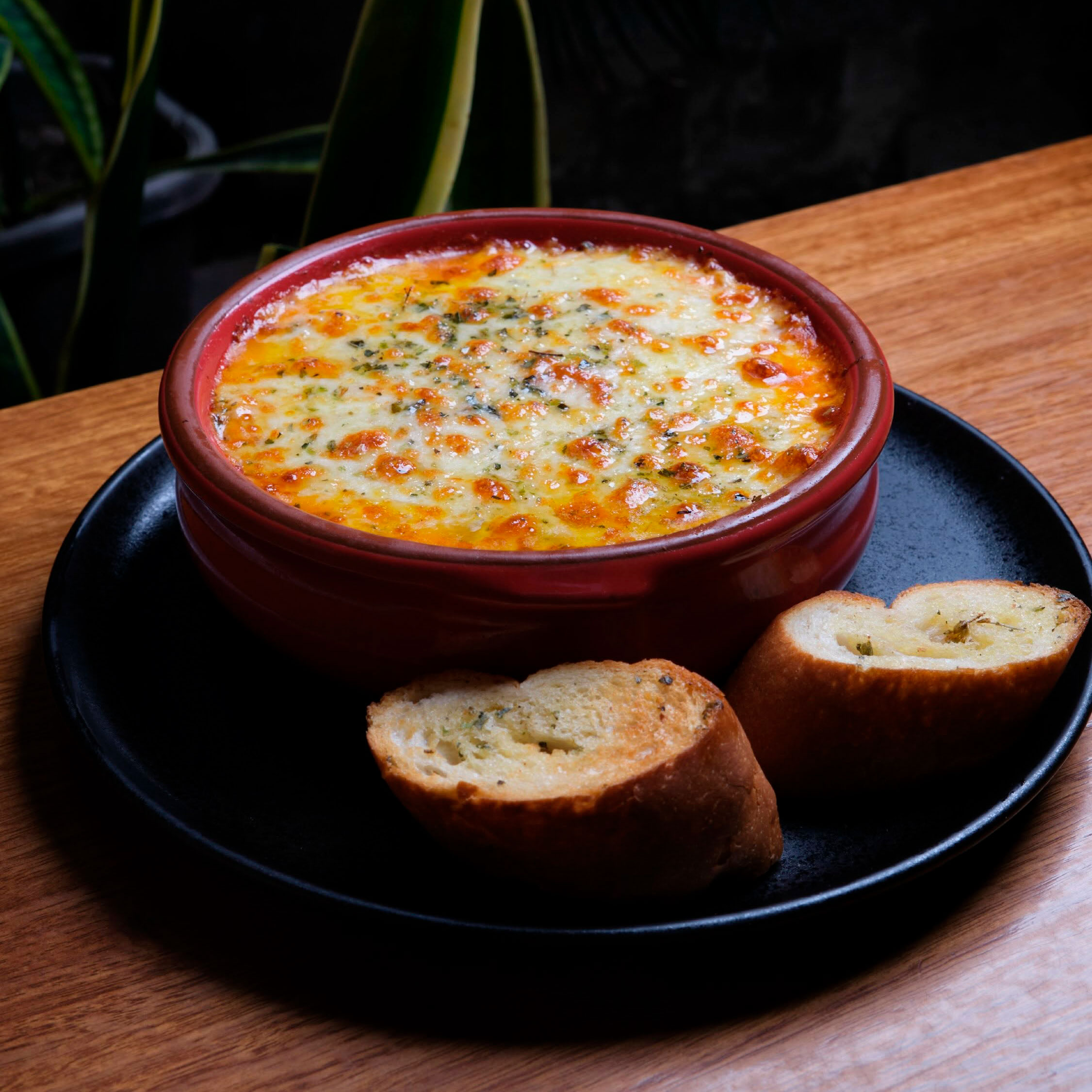 Lasaña mixta gratinada con mozzarella en cazuela roja y dos rebanadas de pan de ajo, Morelia Parrilla Loja